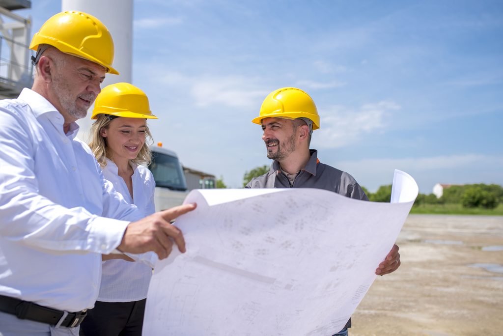 Servicios group of construction workers looking at the plans and documents under the sunlight