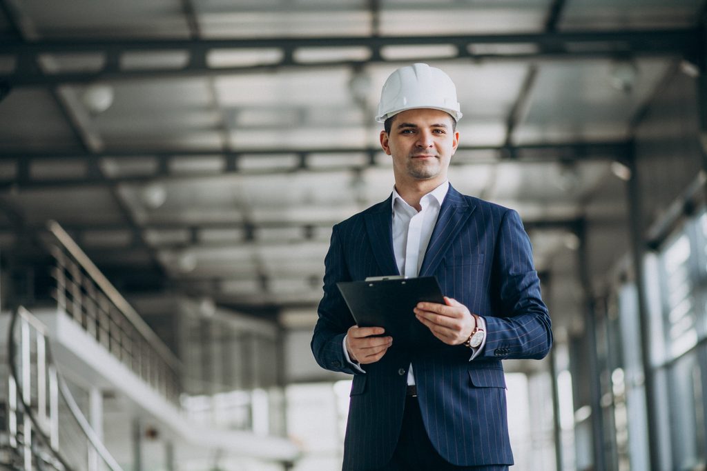 Servicios handsome business man engineer in hard hat in a building